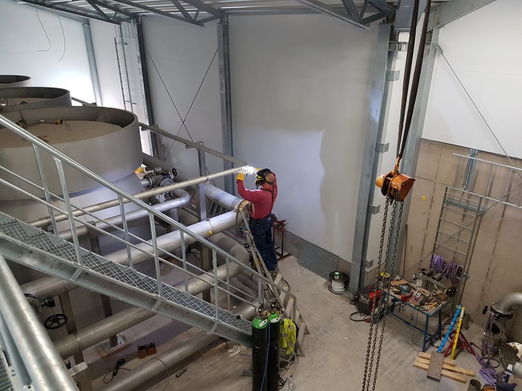 Welder performing process piping welding at a new pump station