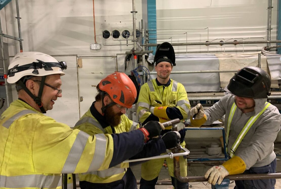 Pipe Fabrication: smiling installers assembling a pipeline