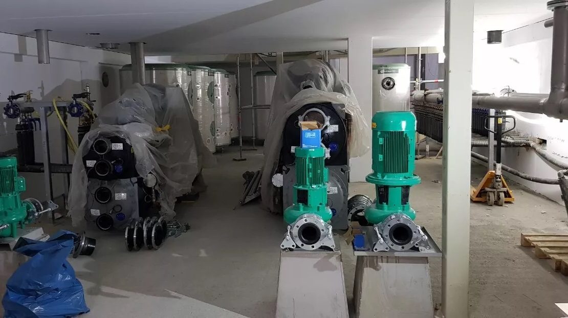Teknisk rum i en ny byggnad där pumpar och en kompressor ska installeras – byggnadens klimatkontrollsystem.
