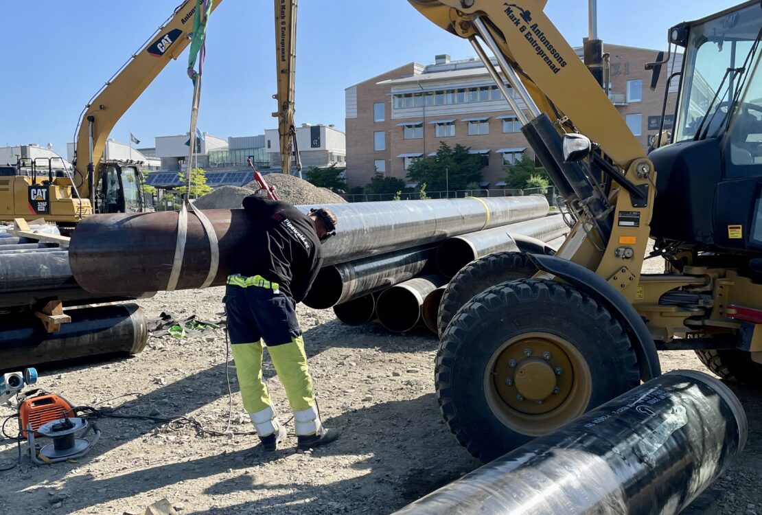 Mechanical Contractor — welder aligning a pipe with help from a forklift.