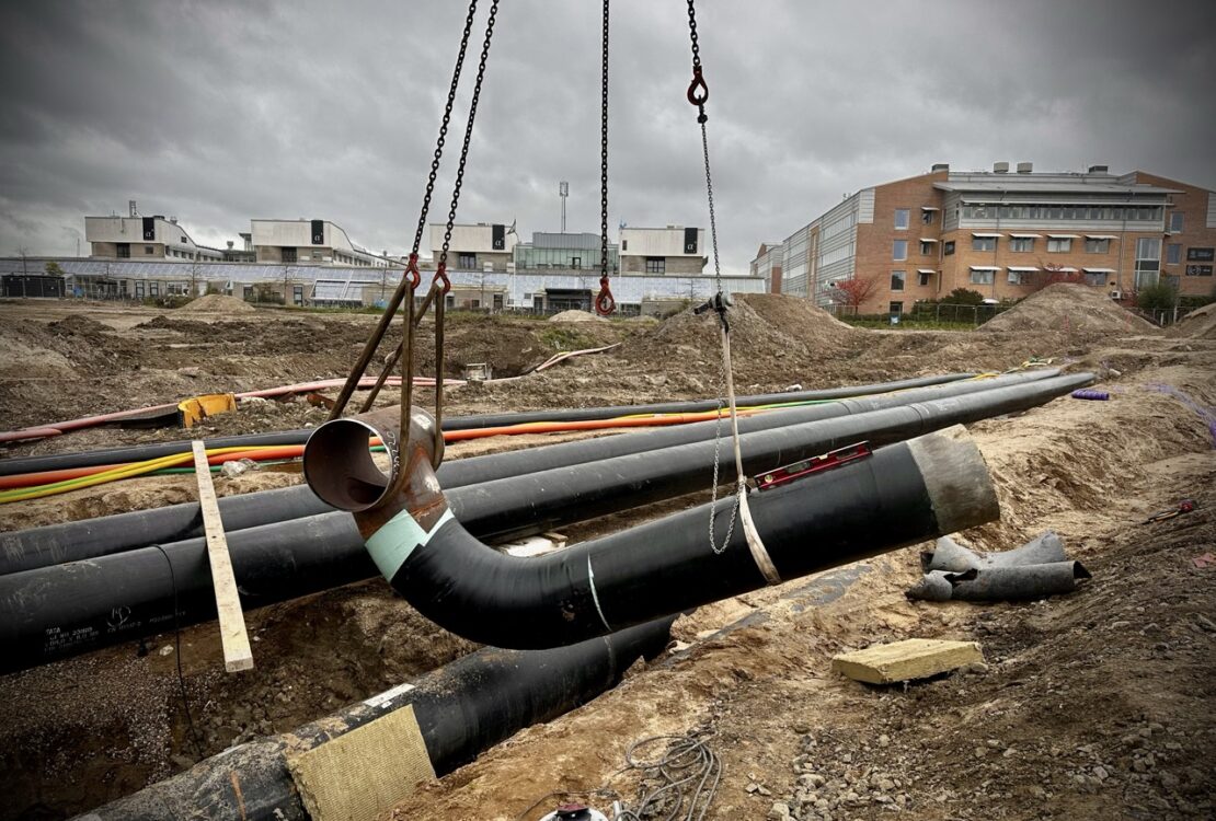 A DN 400 pipeline section suspended by a crane during the pipe fabrication process. The prefabricated pipe spool is being moved for installation or further welding.